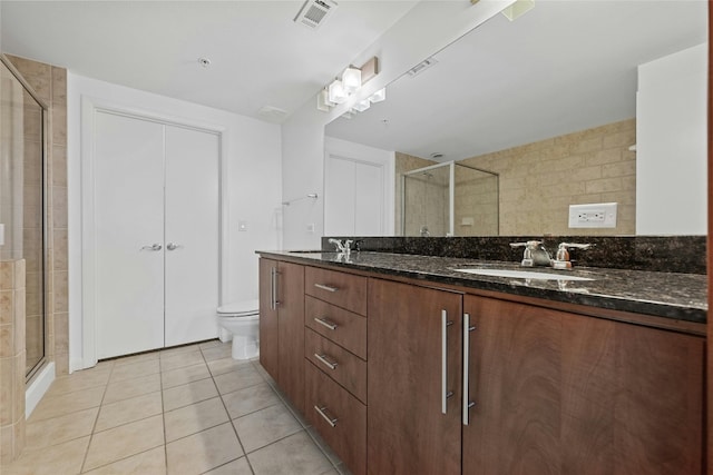 bathroom featuring walk in shower, tile patterned flooring, vanity, and toilet