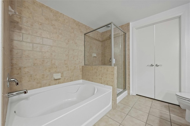 bathroom with tile patterned floors, separate shower and tub, and toilet