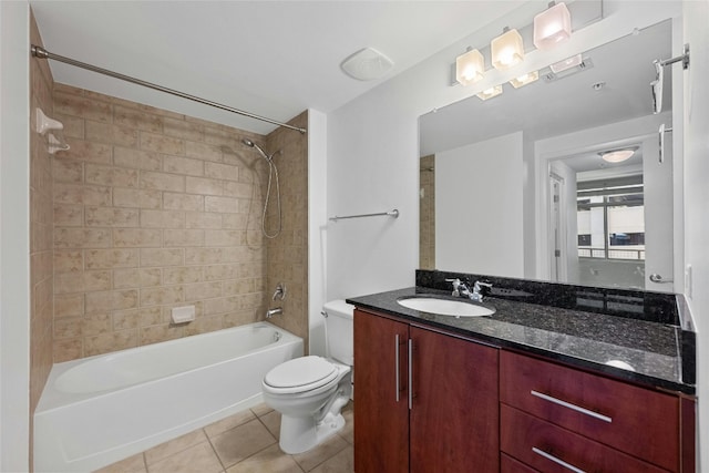 full bathroom featuring tile patterned floors, tiled shower / bath combo, toilet, and vanity