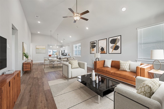 living room featuring hardwood / wood-style flooring, high vaulted ceiling, and ceiling fan