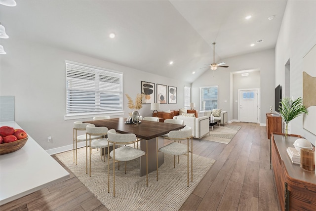 dining area featuring ceiling fan, high vaulted ceiling, and light hardwood / wood-style floors