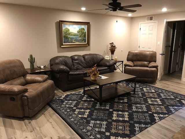 living room featuring ceiling fan and light hardwood / wood-style flooring