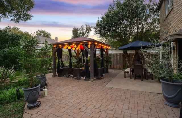 patio terrace at dusk featuring a gazebo