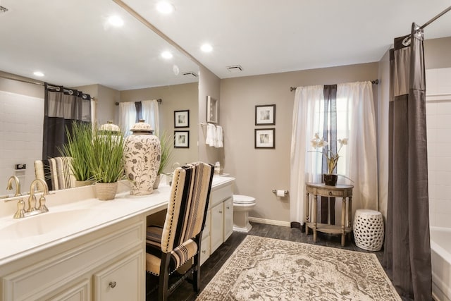 full bathroom featuring hardwood / wood-style flooring, vanity, toilet, and shower / bathtub combination with curtain