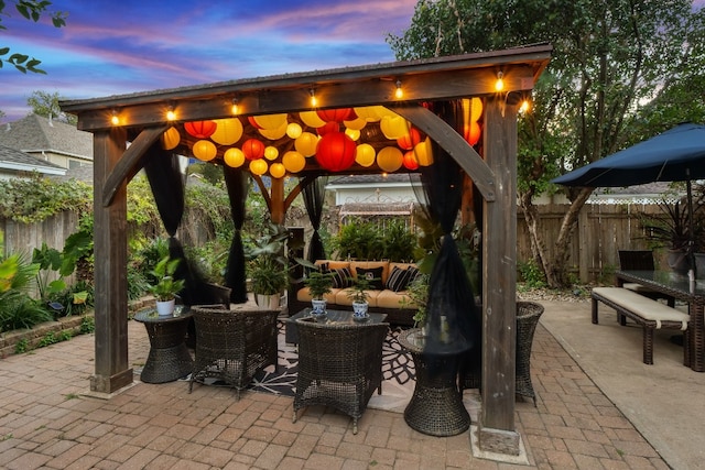 patio terrace at dusk featuring a gazebo and an outdoor hangout area