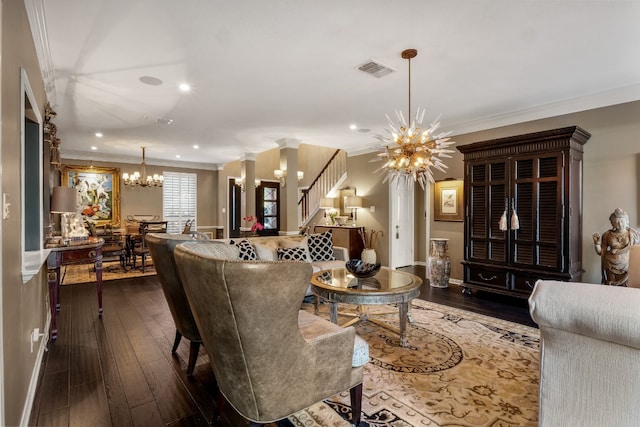 living room with dark hardwood / wood-style floors, crown molding, and an inviting chandelier