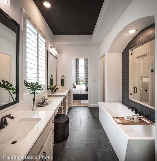 bathroom with plus walk in shower, vanity, tile patterned flooring, and a wealth of natural light