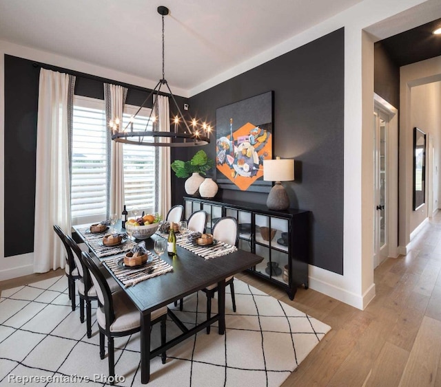 dining space featuring light hardwood / wood-style flooring and a notable chandelier