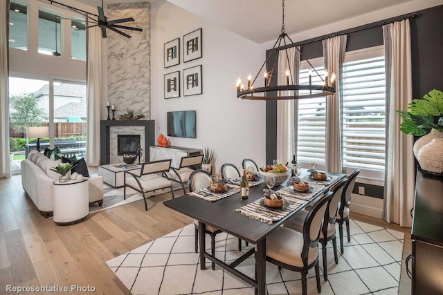 dining room featuring a healthy amount of sunlight, ceiling fan with notable chandelier, and light wood-type flooring