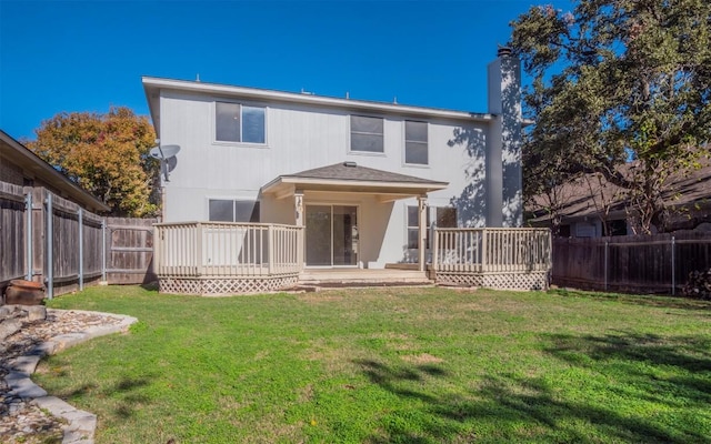 back of property featuring a wooden deck and a yard