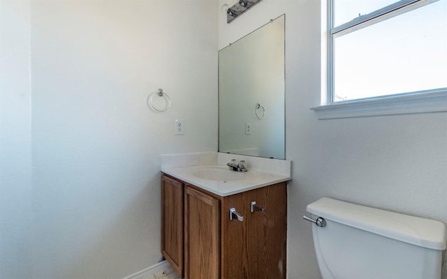 bathroom with vanity, a healthy amount of sunlight, and toilet