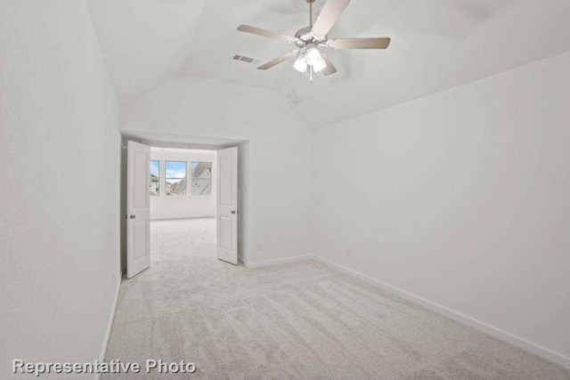 empty room with ceiling fan, light carpet, and vaulted ceiling