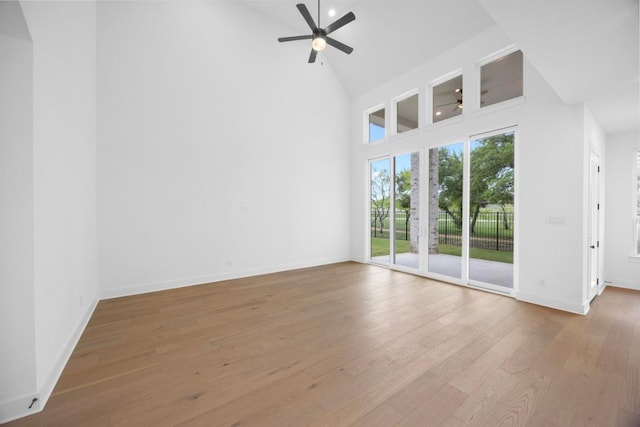 unfurnished living room with wood finished floors, high vaulted ceiling, baseboards, and a ceiling fan