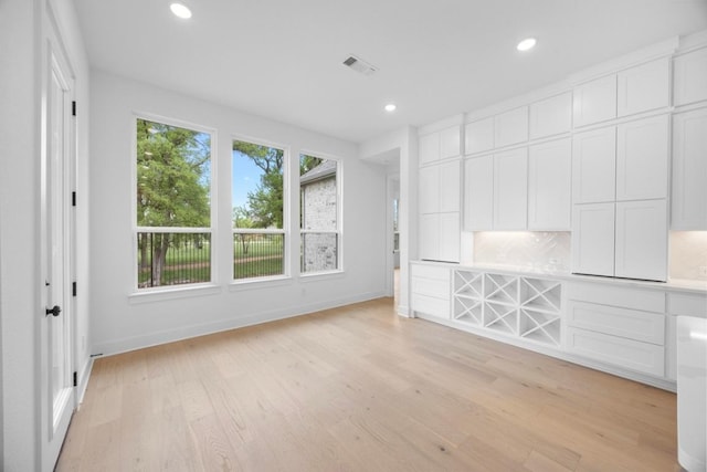 unfurnished living room featuring recessed lighting, light wood finished floors, visible vents, and baseboards