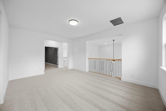 empty room with visible vents, baseboards, and carpet floors
