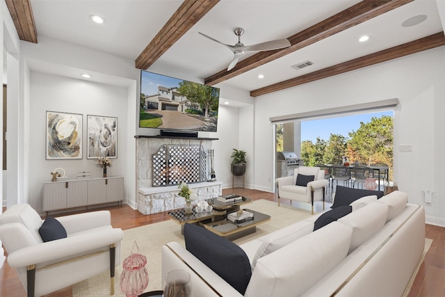 living room featuring beamed ceiling, hardwood / wood-style floors, and ceiling fan