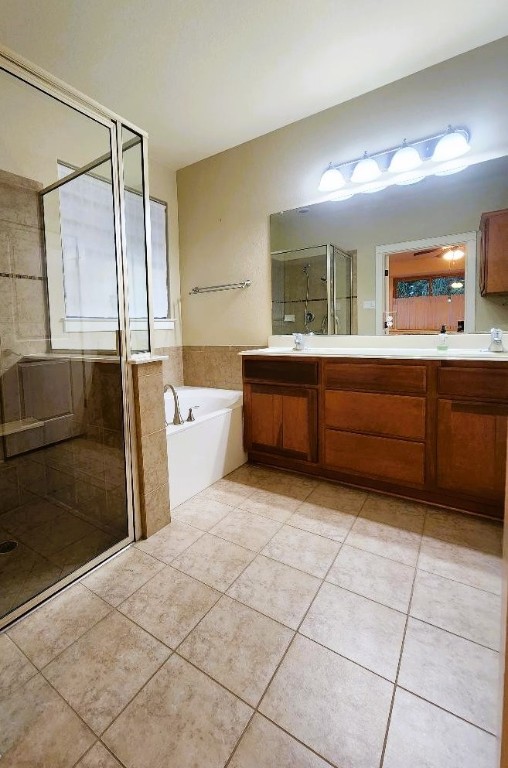 bathroom featuring tile patterned flooring, vanity, and shower with separate bathtub