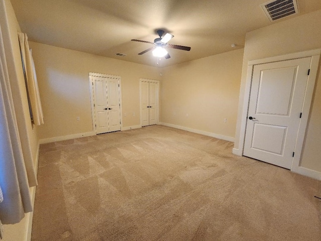 unfurnished bedroom featuring light colored carpet and ceiling fan