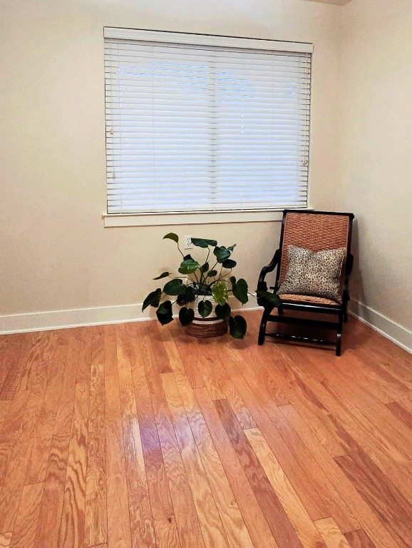 living area with light wood-style flooring and baseboards