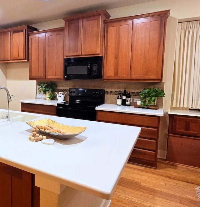 kitchen with black appliances, light countertops, and a sink