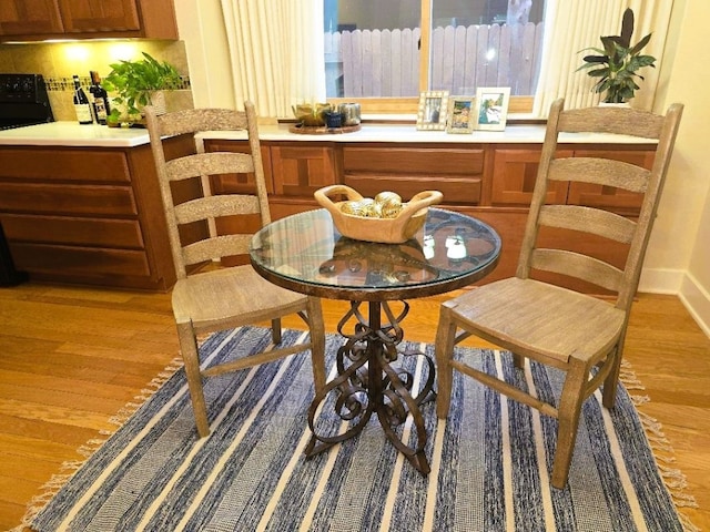 dining area featuring light wood-style flooring and baseboards