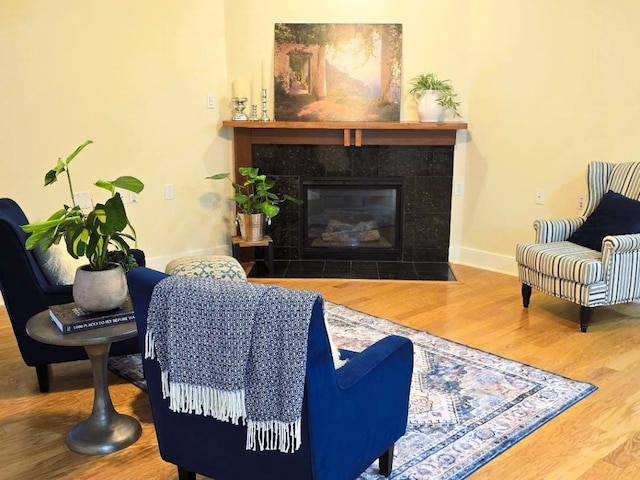 living room with a fireplace, wood finished floors, and baseboards