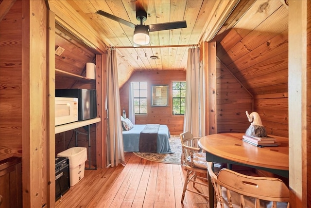 interior space with wood walls, light hardwood / wood-style floors, lofted ceiling, and wood ceiling