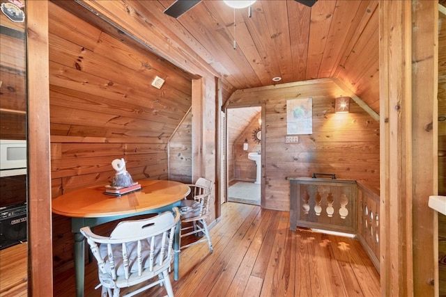 additional living space featuring wood walls, light hardwood / wood-style flooring, wood ceiling, and vaulted ceiling