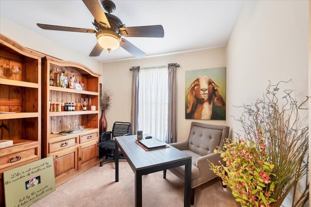 carpeted home office featuring ceiling fan