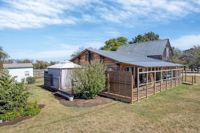 back of property featuring a lawn and an outbuilding