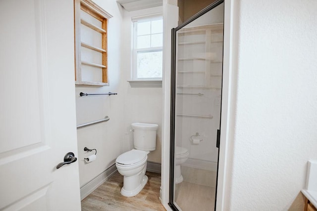 full bath with baseboards, a shower stall, toilet, and wood finished floors