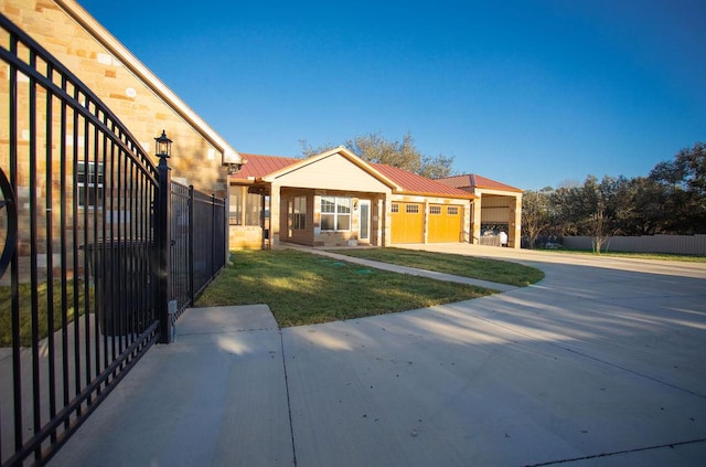 view of front of home featuring concrete driveway, a standing seam roof, metal roof, fence, and a garage