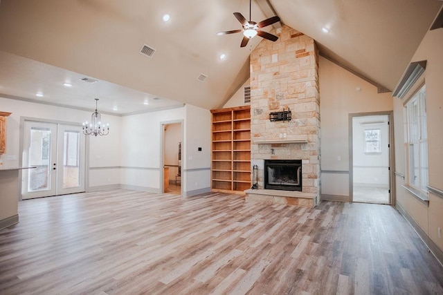 unfurnished living room featuring visible vents, light wood-style flooring, french doors, a fireplace, and high vaulted ceiling