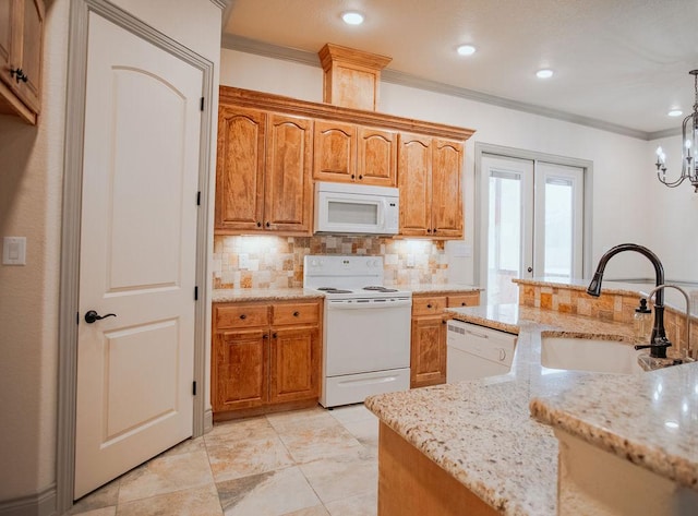 kitchen featuring pendant lighting, ornamental molding, a sink, light stone countertops, and white appliances