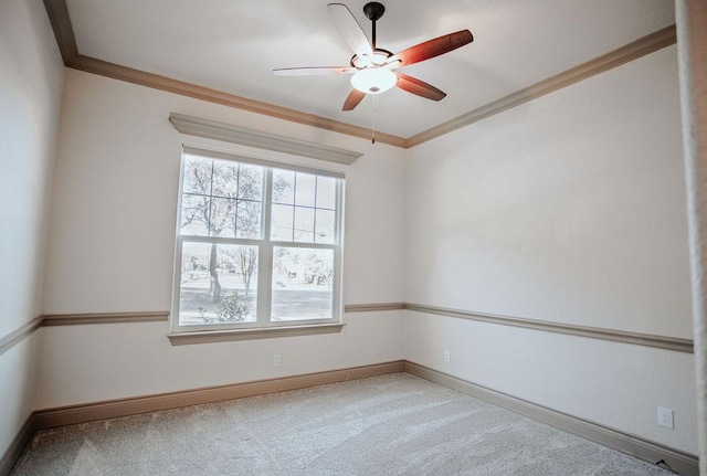 carpeted empty room with baseboards, ornamental molding, and ceiling fan