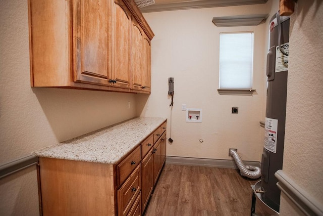 laundry room featuring cabinet space, baseboards, gas dryer hookup, wood finished floors, and electric dryer hookup