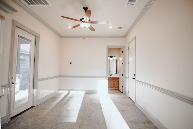 empty room featuring baseboards, visible vents, and ornamental molding