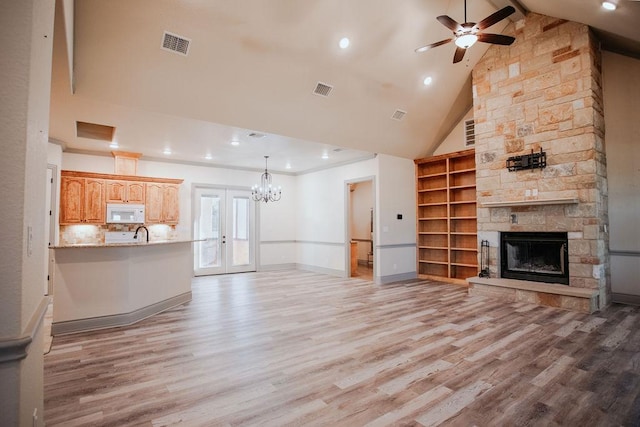 unfurnished living room featuring high vaulted ceiling, light wood-style flooring, visible vents, and french doors