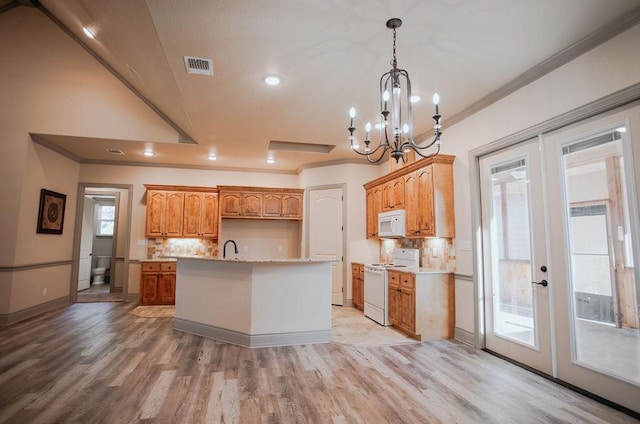 kitchen featuring a kitchen island with sink, white appliances, visible vents, hanging light fixtures, and french doors