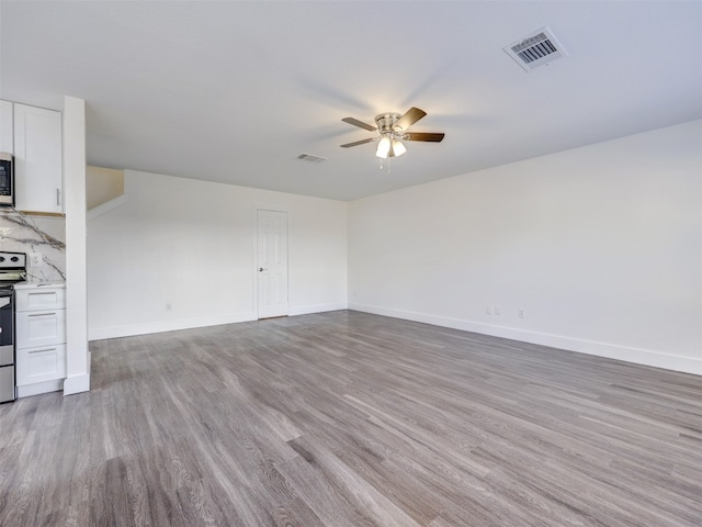 unfurnished living room with ceiling fan and light wood-type flooring