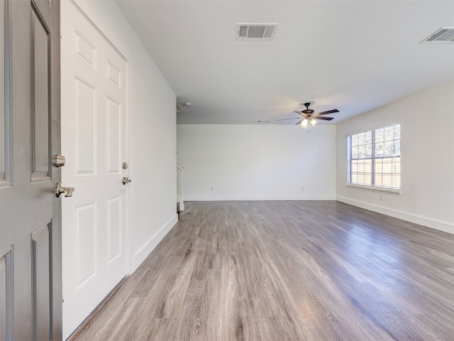 empty room with ceiling fan and light hardwood / wood-style floors