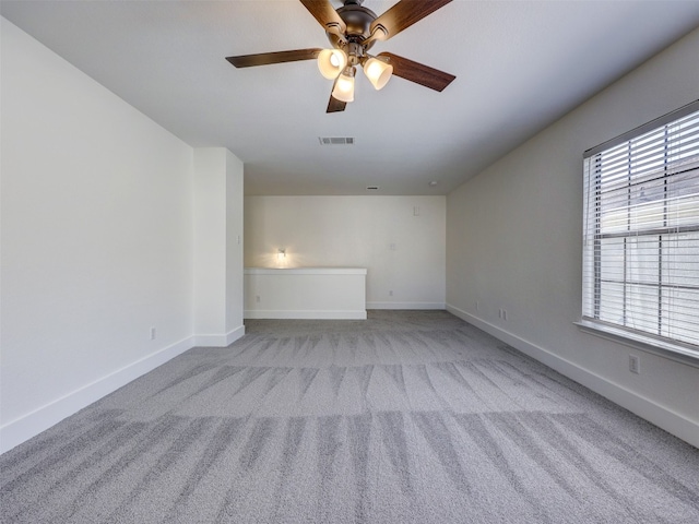 unfurnished room with light carpet, ceiling fan, and a healthy amount of sunlight