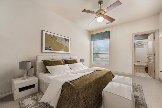 bedroom with light carpet, ensuite bath, and ceiling fan