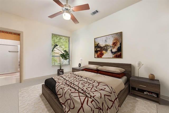 bedroom featuring ceiling fan, ensuite bathroom, and light carpet