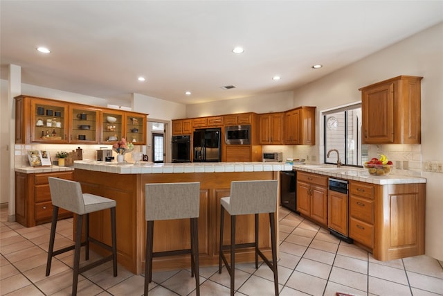 kitchen with a center island, a wealth of natural light, and black appliances