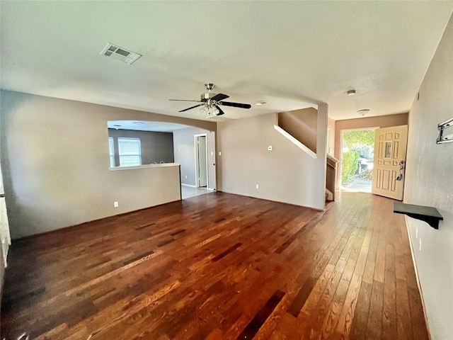 unfurnished living room with ceiling fan, plenty of natural light, and wood-type flooring