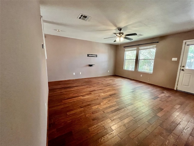 empty room with ceiling fan, hardwood / wood-style floors, and a healthy amount of sunlight