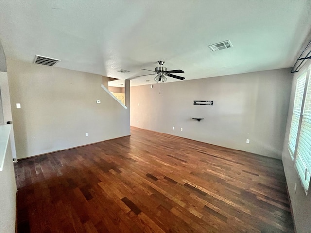 unfurnished living room featuring ceiling fan and dark hardwood / wood-style flooring