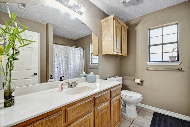 bathroom with vanity, a textured ceiling, tile patterned floors, and toilet