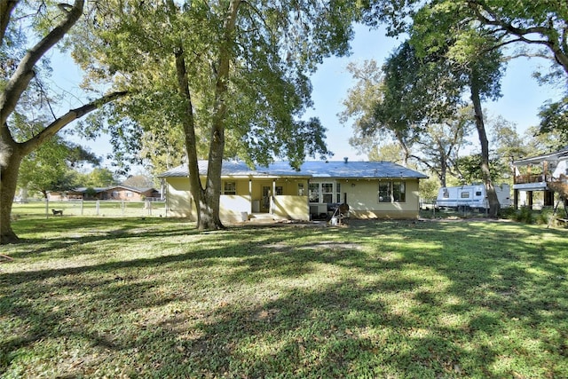 rear view of property featuring a yard